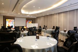 a conference room with tables and chairs and a screen at Qaser Alhamra Hotel Riyadh in Riyadh +26 photos