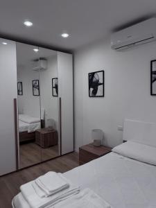 a white bedroom with a mirror and a bed at The Terry Inn in Frascati