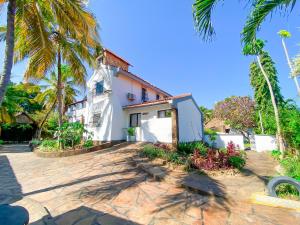 a house with palm trees in front of it at 9 bedroom Villa in Mombasa