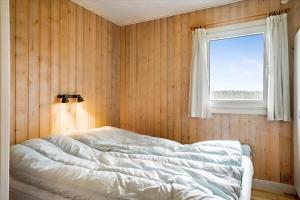 a bedroom with a large bed with a window at FY140-Middelfart-Regulusvej-32 in Middelfart