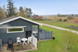 a black house with a patio and a table and chairs at FY140-Middelfart-Regulusvej-32 in Middelfart