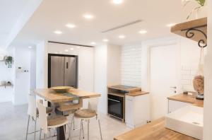 a kitchen with a wooden table and stools at סוויטת לה פלמורה in Eilat