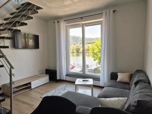 a living room with a couch and a large window at Boendgen's Ferienhaus mit Moselblick in Zell an der Mosel