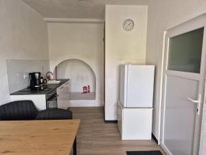 a kitchen with a white refrigerator and a table at Boendgen's Ferienhaus mit Moselblick in Zell an der Mosel