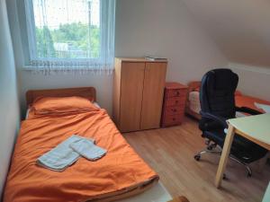 a bedroom with a bed and a desk and a chair at Bella Vendégház in Székesfehérvár +7 photos