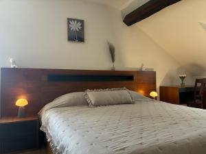 a bedroom with a large bed with a wooden headboard at Auberge de la Charrue in Romanel-sur-Lausanne +28 photos
