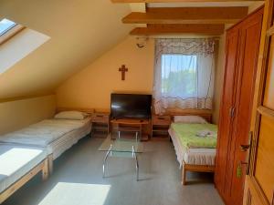 a small room with two beds and a tv at Bella Vendégház in Székesfehérvár