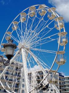 a ferris wheel in front of a building at Italy Luxury Apartment front of the sea in Mamaia Sat/Năvodari