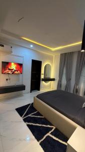 a bedroom with a bed and a tv on the wall at The bliss spot in Lekki