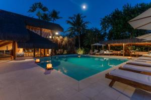 a swimming pool with lounge chairs and a resort at Hotel e Resort Villas de Trancoso in Trancoso