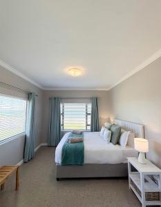 a bedroom with a large bed and a window at Franskraal Zeehoek in Franskraalstrand
