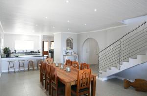 a kitchen and dining room with a wooden table and chairs at Franskraal Zeehoek in Franskraalstrand