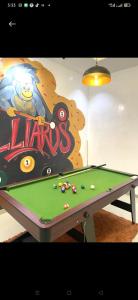 a pool table in front of a video game sign at Dee's Apartment in Gwarinpa