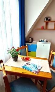 a table with a bowl of watermelon and a plant on it at Willa Zacisze Sianożęty in Sianozety