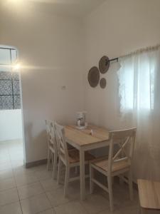 a kitchen with a wooden table with chairs and a pan at Casa de Playa in Salamina