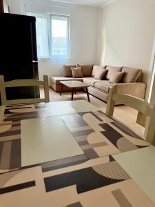 a living room with a couch and a table at EG Beach Apartments 105A in Lezhë