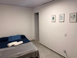 a bedroom with a bed and some pictures on the wall at Suíte Brisa Mar Saquarema in Saquarema