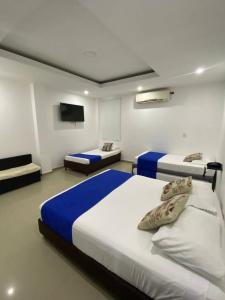 a bedroom with two beds and a flat screen tv at Hotel Diamonds in Ríohacha +41 photos
