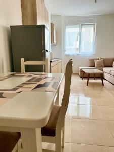 a kitchen and living room with a table and chairs at EG Beach Apartments 105A in Lezhë