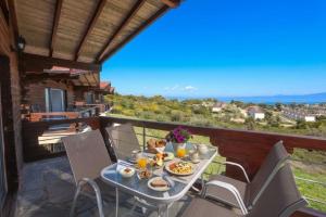 a table with food and drinks on a balcony at Hilltop Chalet 5 in Hanioti