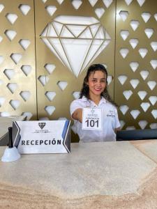 a young girl standing next to a table with a registration box at Hotel Diamonds in Ríohacha