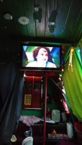 a television with a woman on it in a room at Small Rosie River Glamping Pod for 1 in Lincoln