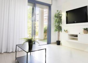 a living room with a tv and a glass table at רויאל דרים אילת in Eilat