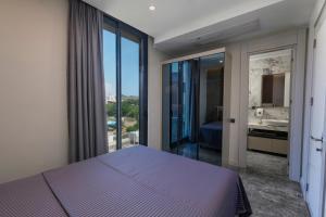 a bedroom with a purple bed and a bathroom at Bodrum Ada Suites Beach Hotel in Turgutreis +102 photos