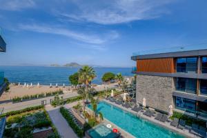 an aerial view of a resort with a swimming pool and a beach at Bodrum Ada Suites Beach Hotel in Turgutreis
