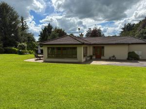 a house with a green lawn in front of it at Borodino Studio Apartment in Enniscorthy