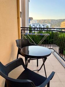 a table and chairs on a balcony with a view at EG Beach Apartments 105A in Lezhë