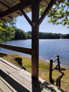 a view of a lake from the porch of a cabin at chalet les pieds dans l'eau in Neuvic