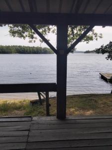 a view of a large lake from a porch at chalet les pieds dans l'eau in Neuvic