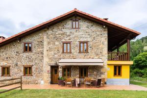 a stone house with a table and chairs in front of it at Casa Santa Leocadia in Tama