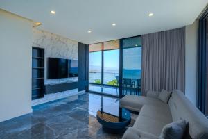 a living room with a couch and a television at Bodrum Ada Suites Beach Hotel in Turgutreis