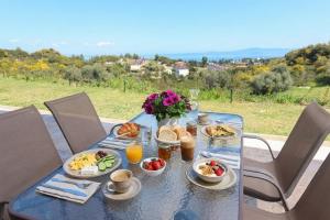 a table with breakfast foods and drinks on it at Hilltop Apartment 6 in Hanioti