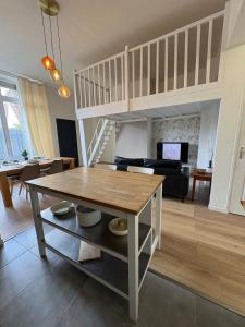 a living room with a table and a loft at Le Cocon de St-Pierre in Calais +2 photos