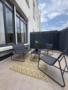 a patio with two chairs and a rug at Le Cocon de St-Pierre in Calais