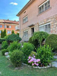 a garden with flowers and bushes in front of a building at Adzija House in Ohrid