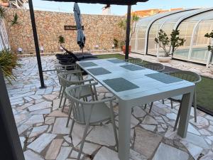 a table with chairs and an umbrella on a patio at Dii Beach House - Piscina Aquecida 28º-32º C in Torres Vedras +16 photos