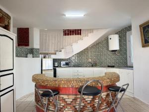 a kitchen with a counter with stools around it at Villa rafraf in Rafrāf +21 photos