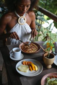 a woman standing at a table with a plate of food at Pousada País Tropical in Icaraí +32 photos