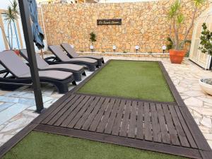 a patio with chairs and a green lawn at Dii Beach House - Piscina Aquecida 28º-32º C in Torres Vedras