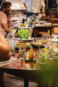 a table with a plate of food and wine glasses at Pousada País Tropical in Icaraí