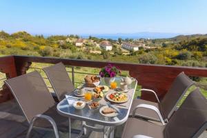 a table with food and drinks on a balcony at Hilltop Chalet 4 in Hanioti +10 photos