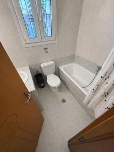 a bathroom with a toilet and a tub and a sink at Seaside Escape in Nea Peramos