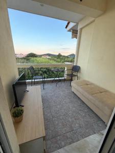 a balcony with a couch and a table and chairs at Seaside Escape in Nea Peramos