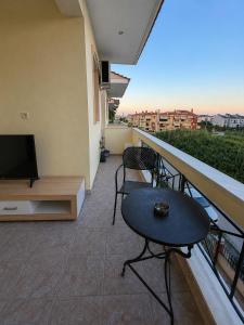 a balcony with a table and chairs and a television at Seaside Escape in Nea Peramos