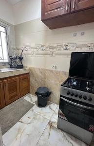 a kitchen with a stove and a sink at Le bungalow by mk in Nzogobeyork +2 photos