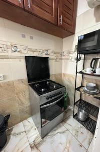 a kitchen with a stove and a tv on the wall at Le bungalow by mk in Nzogobeyork